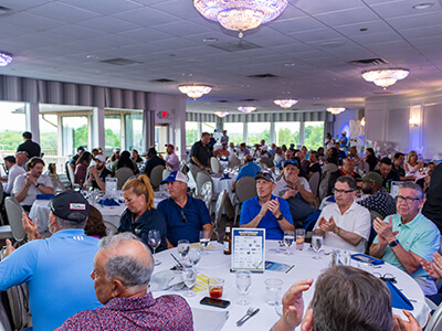 People of various backgrounds sitting at tables in a room, interacting and socializing